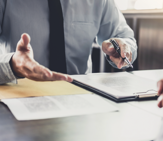 A man signs a document with a pen, becoming an ActOne Government Solutions client.