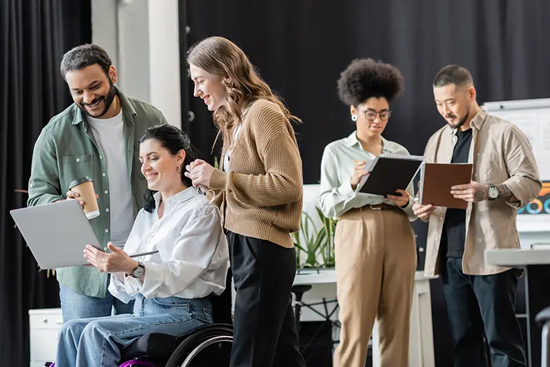 A united group  able-bodied people and person in a wheelchair meeting, highlighting inclusion.