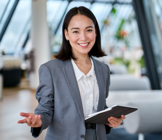  Asian businesswoman smiling, holding clipboard. Let's help you find a HR solution.