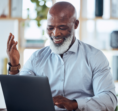 A man with a beard typing on a laptop.